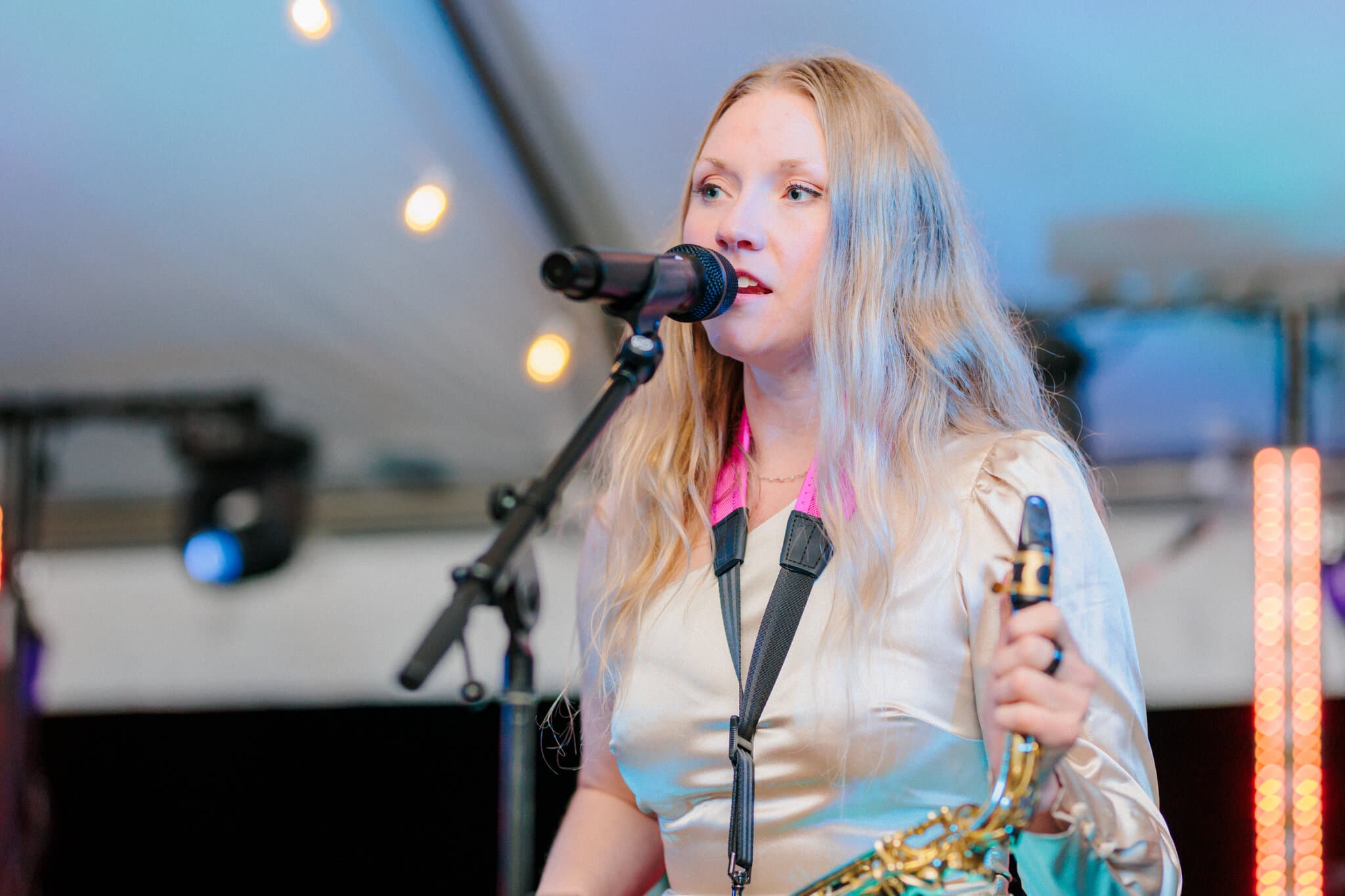 Heads Up Penny vocalist beneath wedding reception string lights